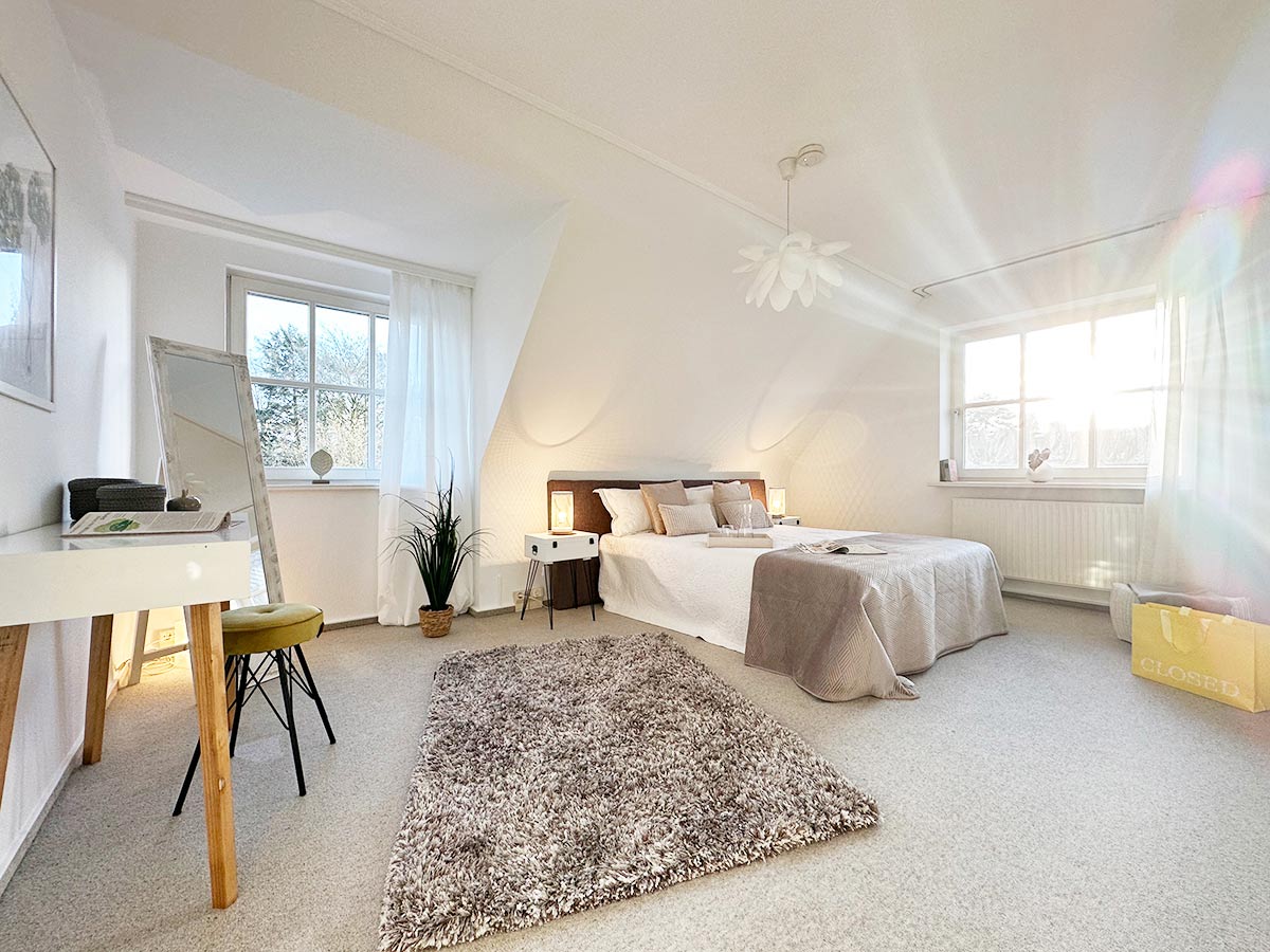 Hauptschlafzimmer mit Boxspringbett und moderner Beleuchtung in Halstenbek